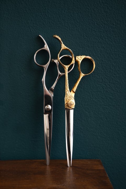 Barber styling hair with professional equipment in modern barbershop